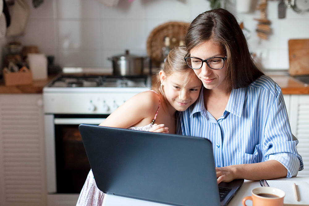 Mother and daughter looking at laptop screen