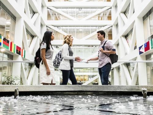 Three business students conversing in BYU's Tanner Building