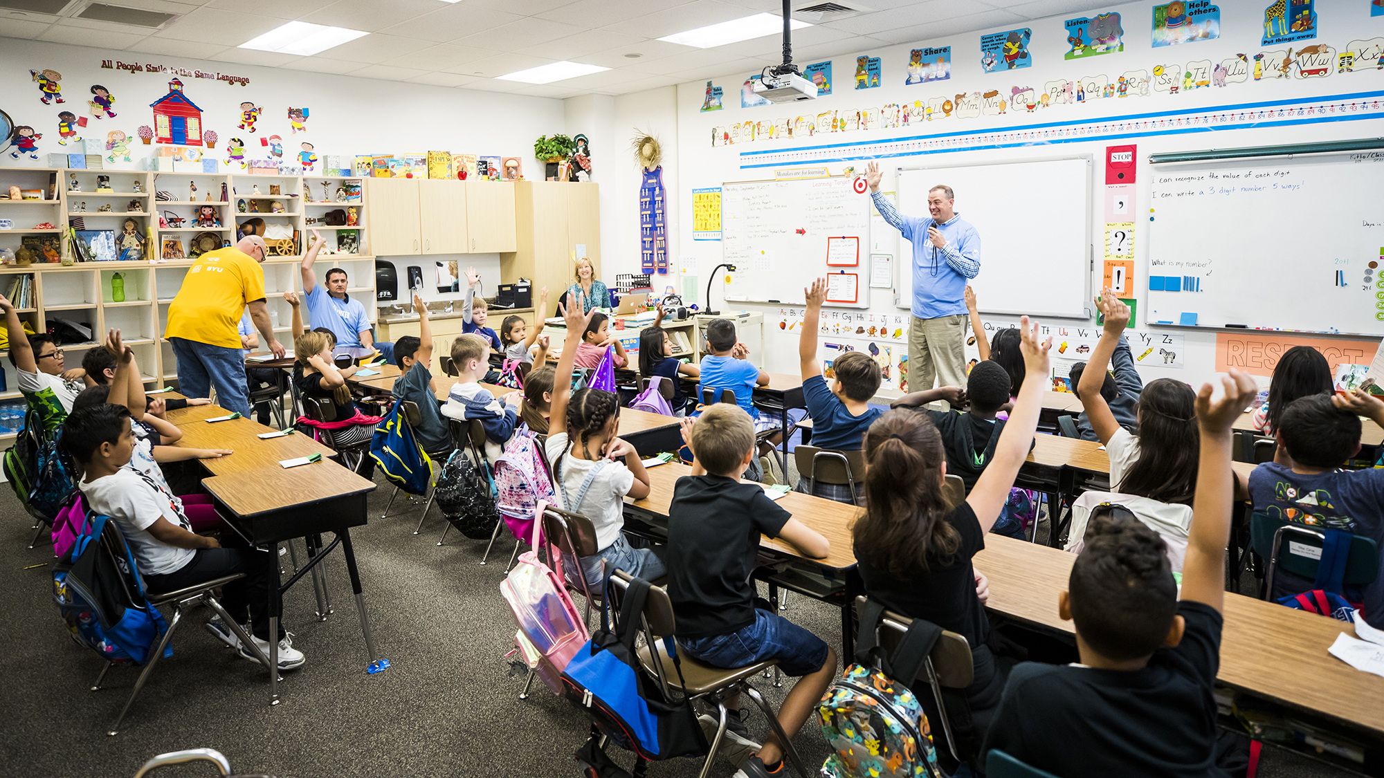 Male teacher in front of an elementary classroom